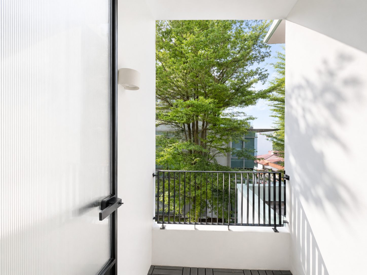The balcony, with the mature tree behind the block