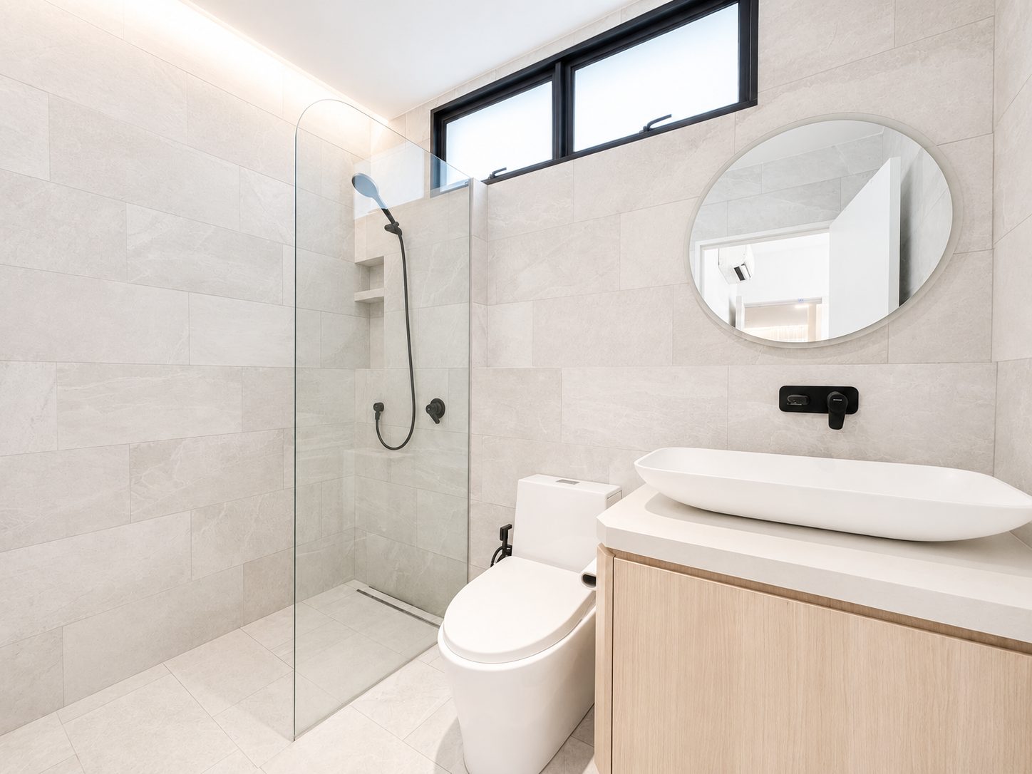 The main bathroom, grey stone-look tile with a walk-in glass shower