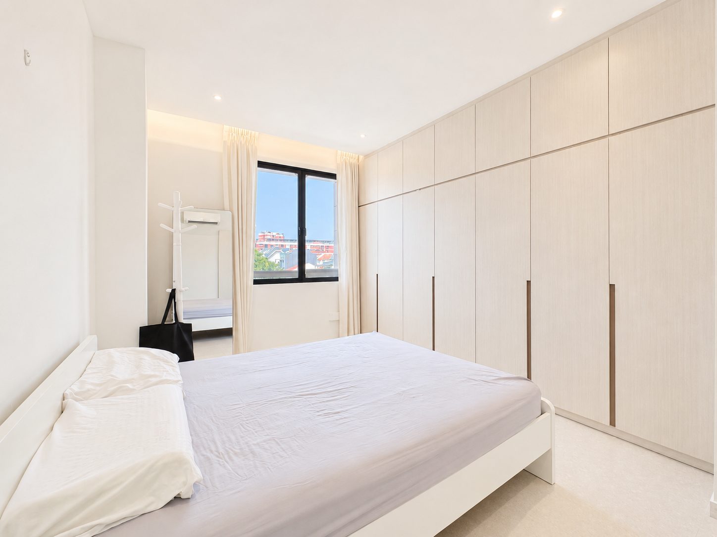 The bedroom, with a full-height fitted wardrobe run